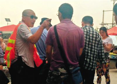 地铁天通苑北站外的广场上，一名套着“Police”（警察）字样背心的人要求摆摊的记者离开，但没驱赶其他摊贩。